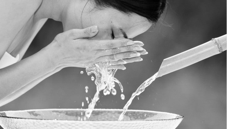 Young woman washing her face